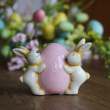 Load image into Gallery viewer, Cerami Bunnies Holding Pink Egg Ornament