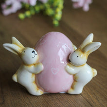 Load image into Gallery viewer, Cerami Bunnies Holding Pink Egg Ornament