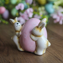 Load image into Gallery viewer, Cerami Bunnies Holding Pink Egg Ornament