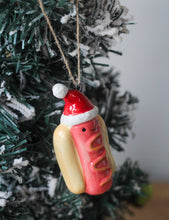 Load image into Gallery viewer, Ceramic Festive Hotdog With Santa Hat Ornament
